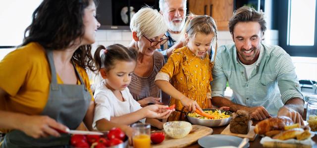 Cheerful family spending good time together while cooking in kitchen